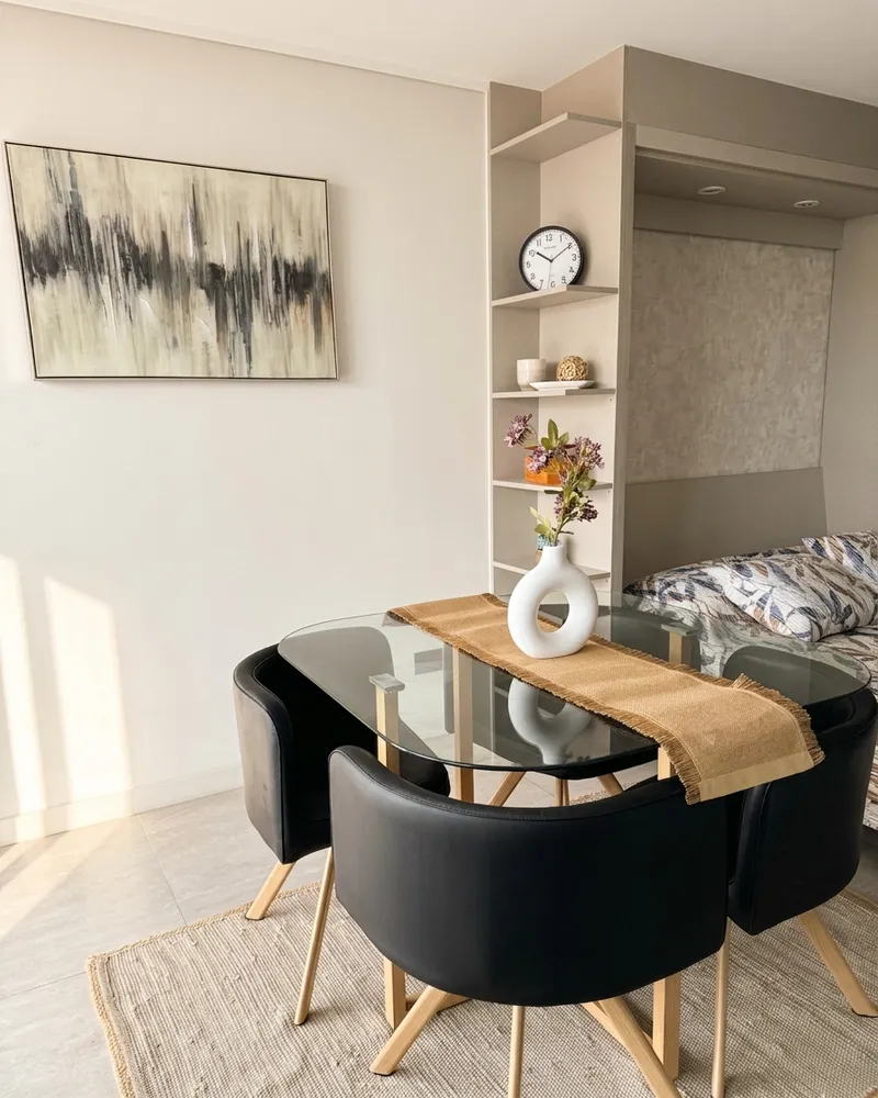 Mesa de comedor de vidrio con cuatro sillas y camino de mesa