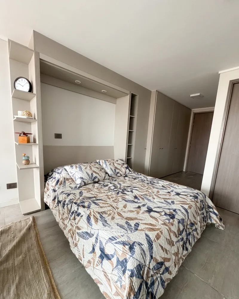 Dormitorio amoblado con la cama montada y ropa de cama limpia